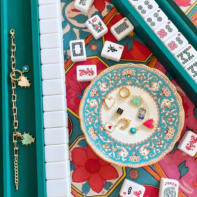 Metropolitan bracelet on a teal Mahjong rack with charms on a decorative plate